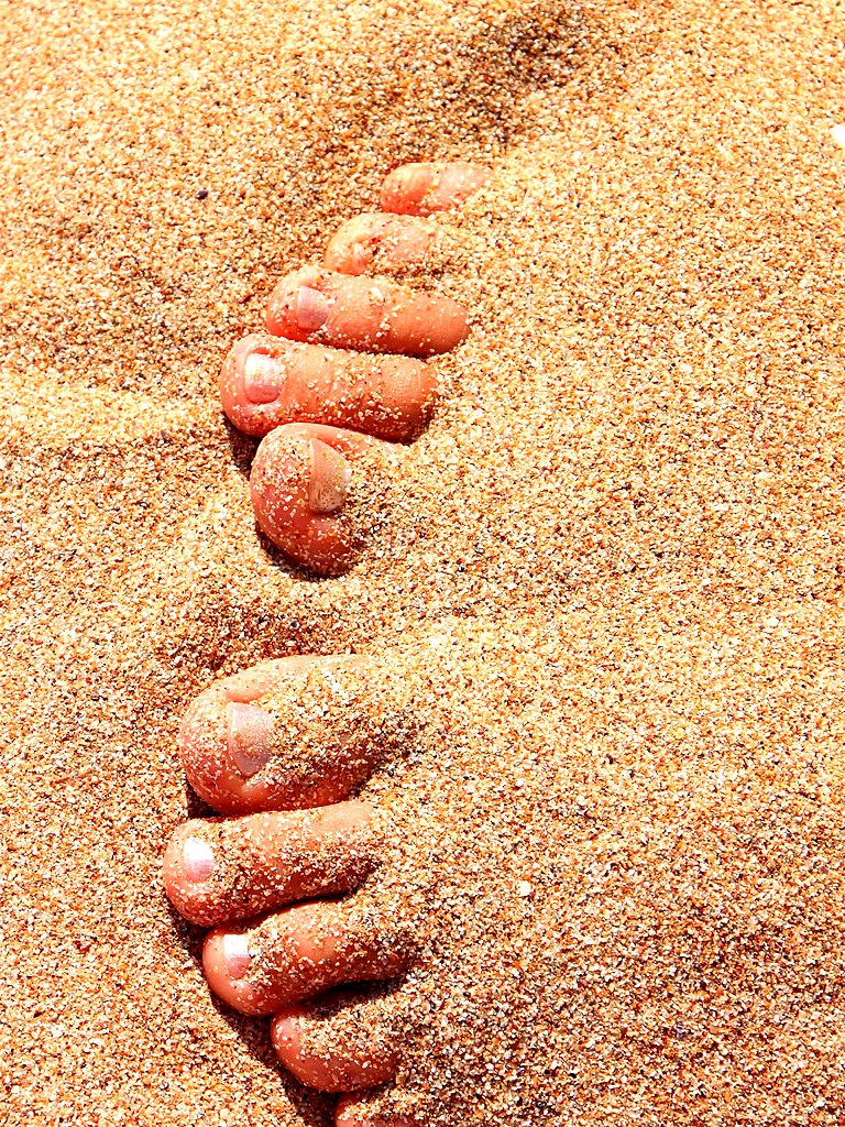 Female-Feet-Covered-With-Sand-On-The-Beach__99973