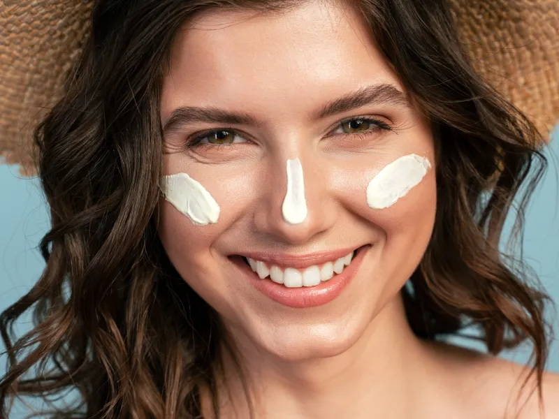 Mulher com protetor solar para o rosto