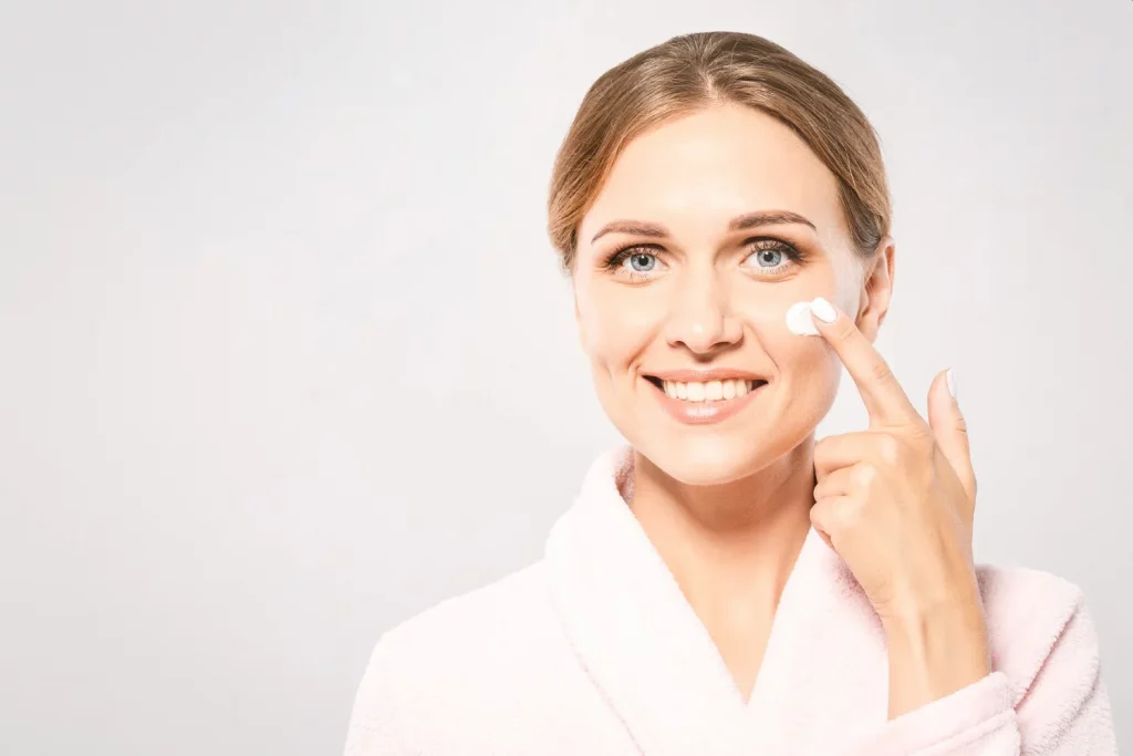 mulher a colocar creme antirrugas no rosto