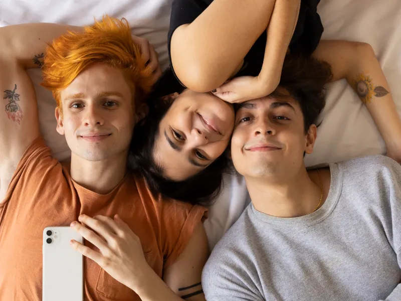 uma selfie de três jovens adolescentes na puberdade deitados numa cama