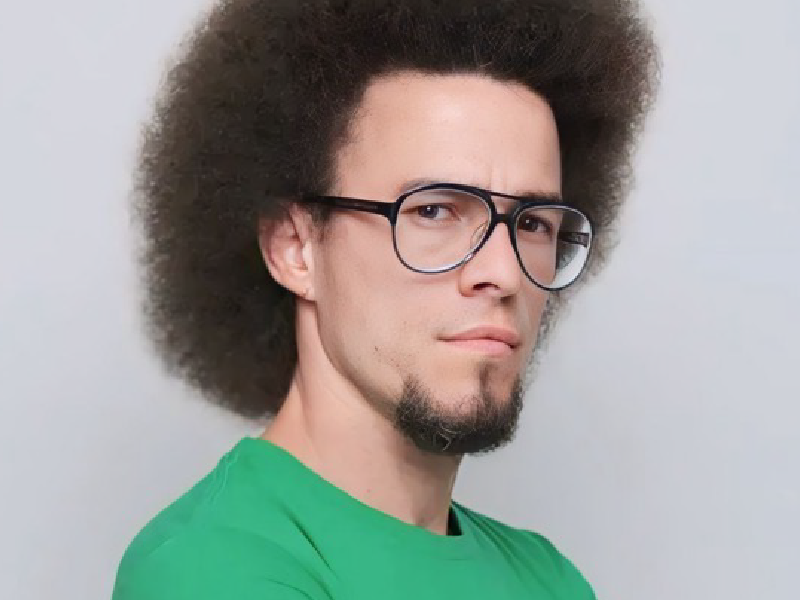 homem de óculos com cabelo tipo afro e barba estilo ""pêra"