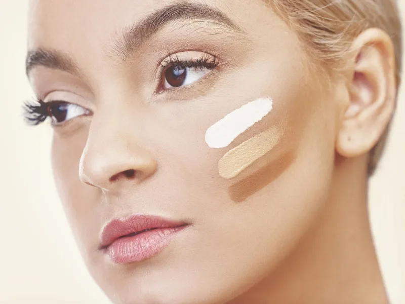 mulher caucasiana a fazer teste de tonalidades de BB creams no rosto