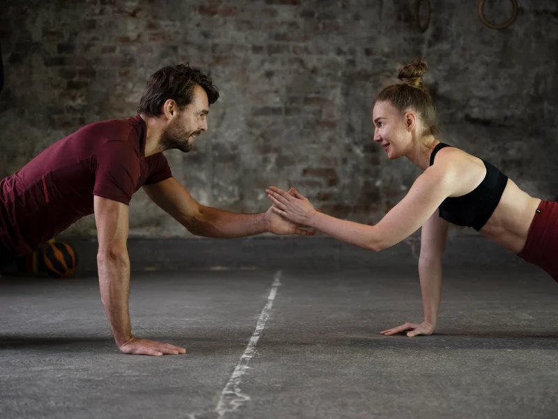 um homem e uma mulher a treinar em conjunto em posição de flexão