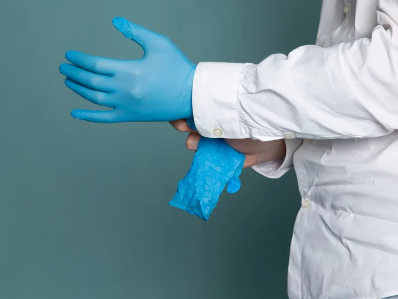 médico a calçar luvas de látex