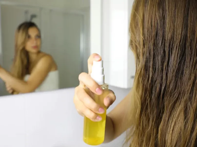 mulher a aplicar spray no cabelo