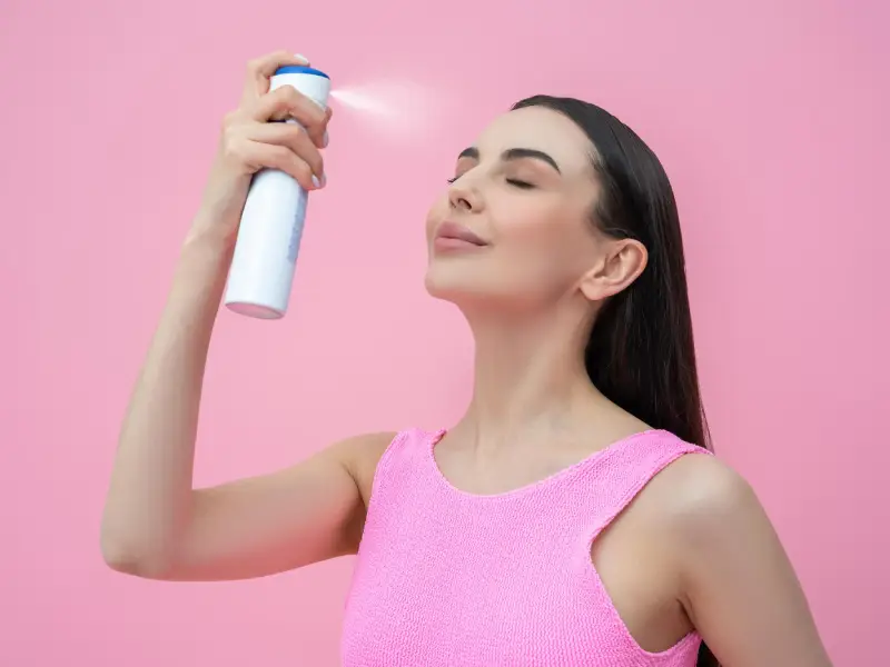 mulher a aplicar face mist