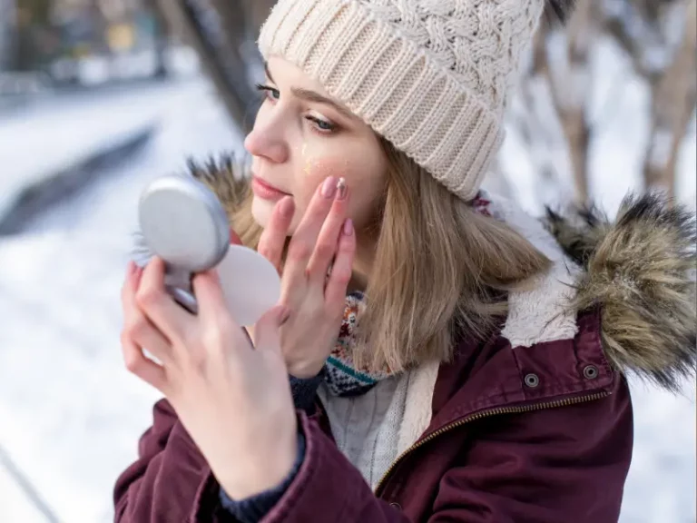 mulher na neve a aplicar skincare