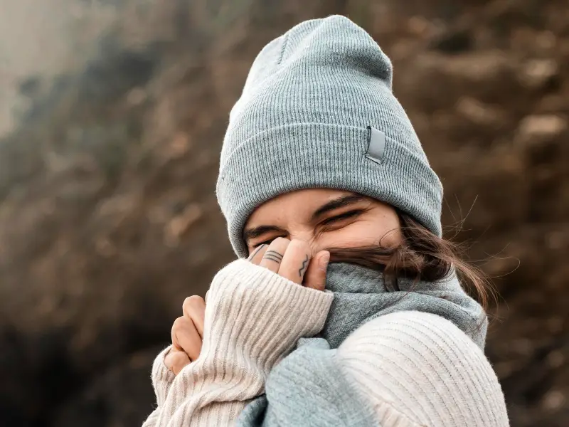 mulher com gorro e cachecol por causa do frio