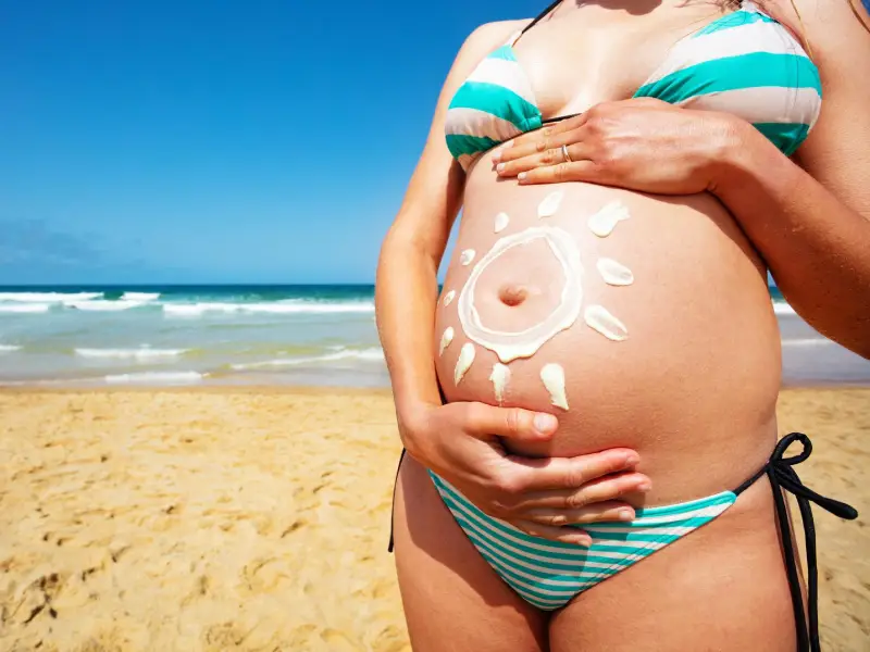barriga de grávida com protetor solar aplicado