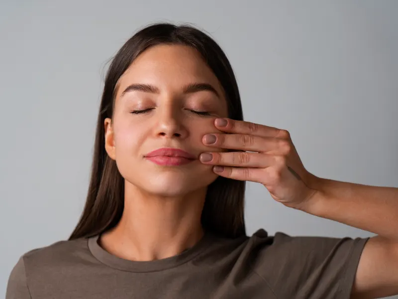 mulher a puxar a bocheca - exercicio yoga facial