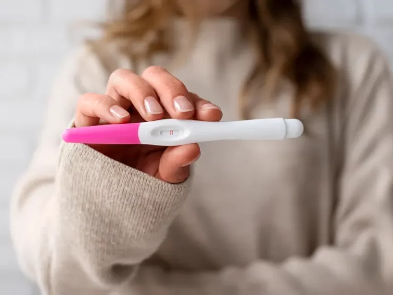 mulher a segurar um teste de gravidez positivo