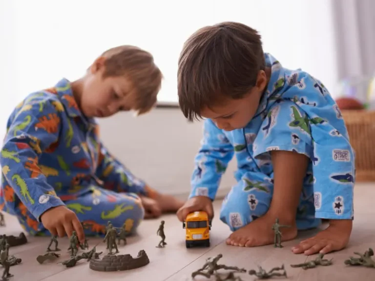 dois meninos a brincar com figuras de ação