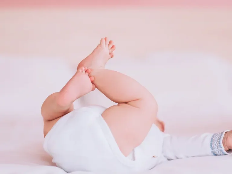 bebe com fralda deitado na cama